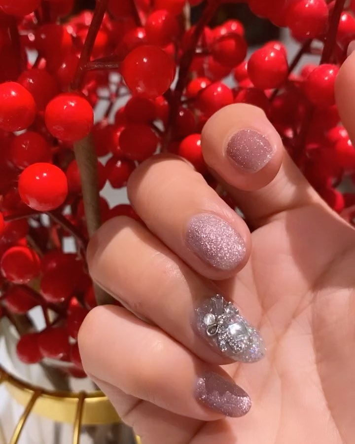 Pink glitter nails with butterfly gem